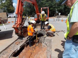 men digging up the road